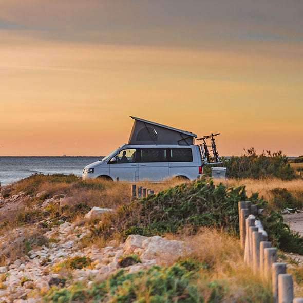 Camper van on the cost watching the sunset.