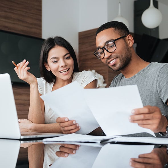 Couple at a computer figuring out their joint finances.