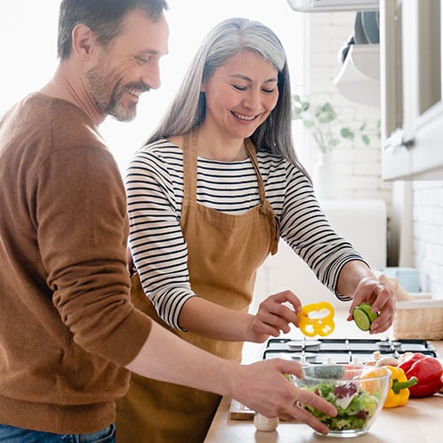 Couple cooking together who are looking forward to retirement and spending time together because of their IRA with PCU.