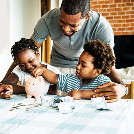 Father and children put money in a piggy bank savings account for youth savings account at PCU