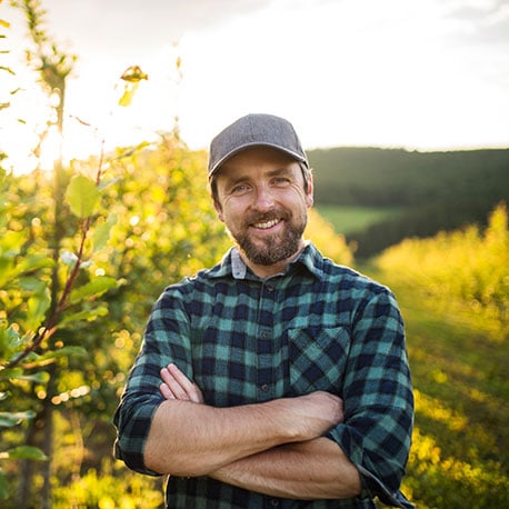 Man in a field at his new home purchased with a USDA loan from CCCU credit union in Portland Oregon.
