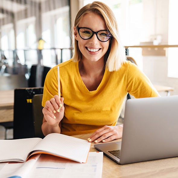 Happy woman on computer checking her FICO credit score.
