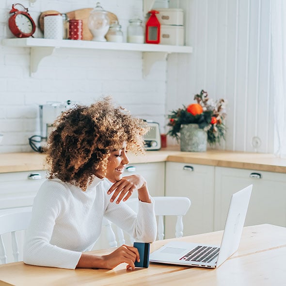 Woman banking on computer using PCU online banking services.