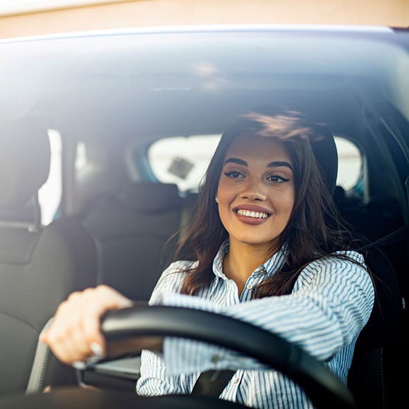 Business woman driving in her vehicle she uses to run her small business.