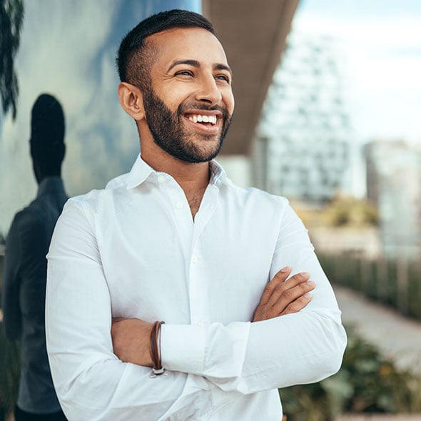 Young man in the city smiling after opening a Base Checking Account.