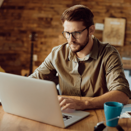 man using PCU online bill pay on his laptop